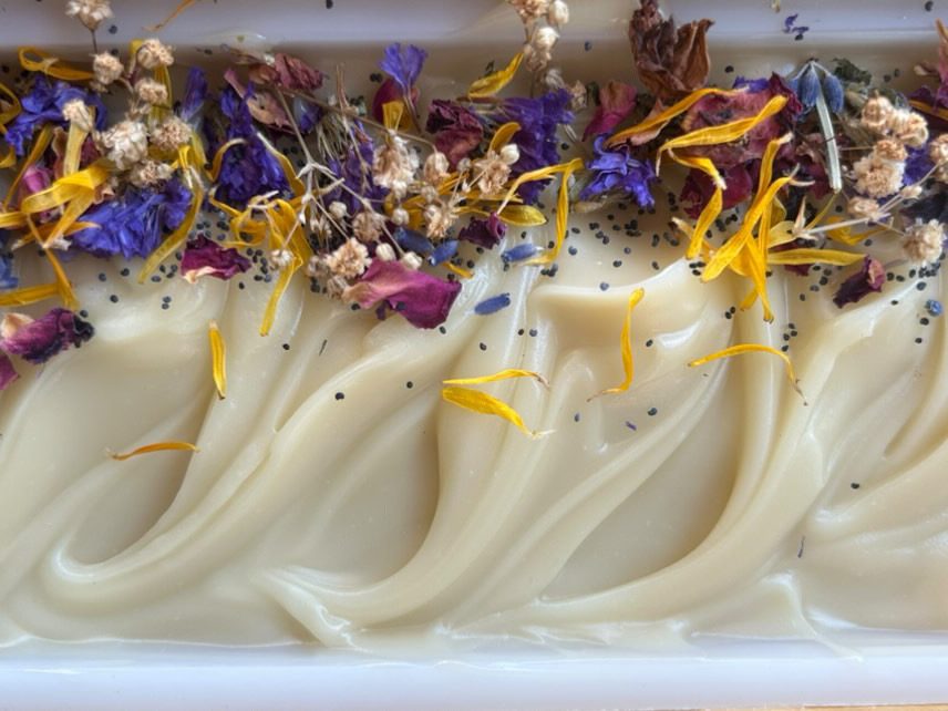 the top of a big slab of wilflower & barley tallow soap showing the wildflowers along the edge