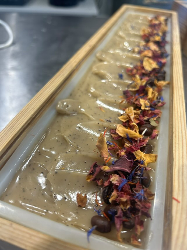 Wet soap in a big block with wild flowers down one side.