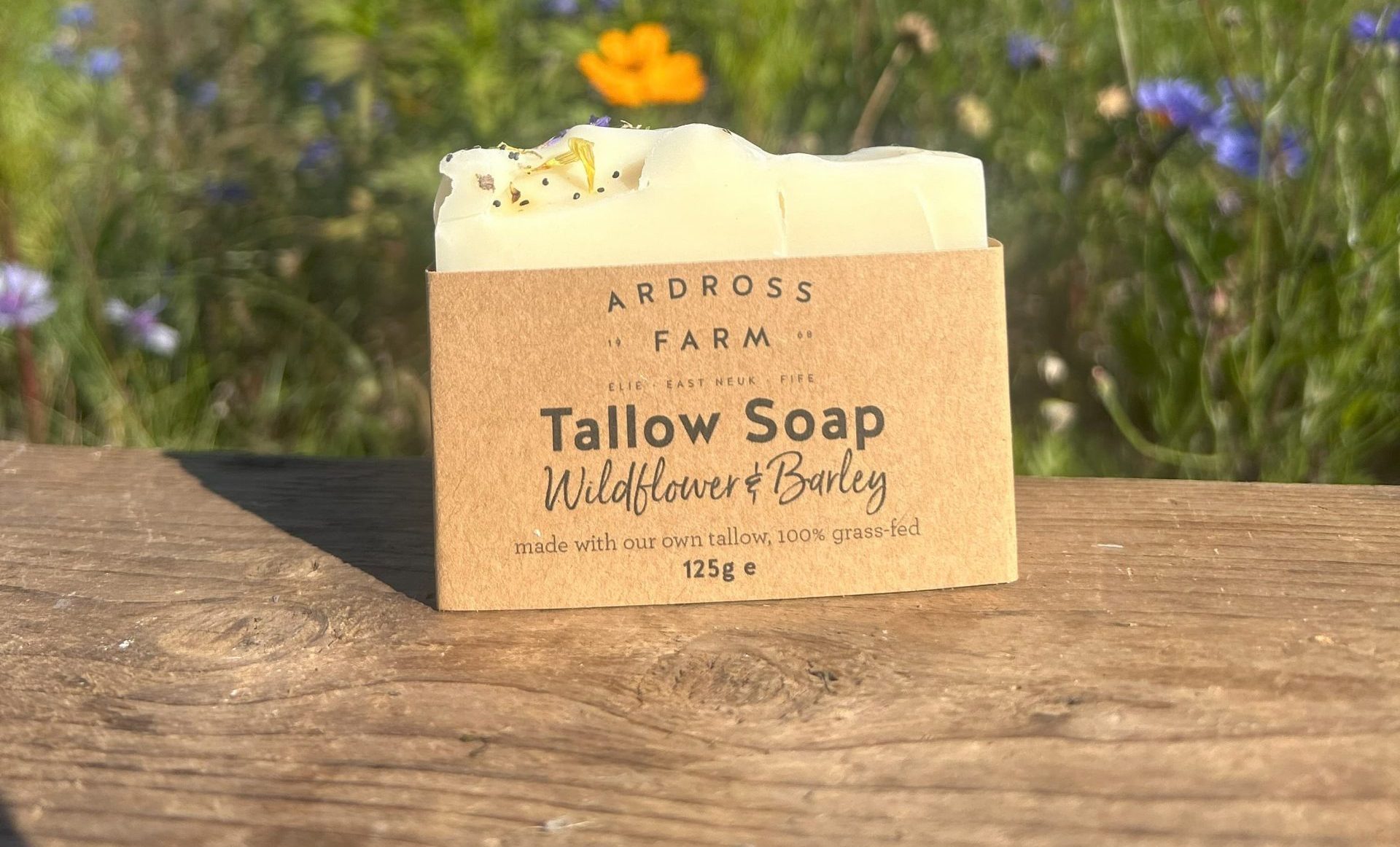 Wildflower tallow soap sitting on wooden table in wildflowers