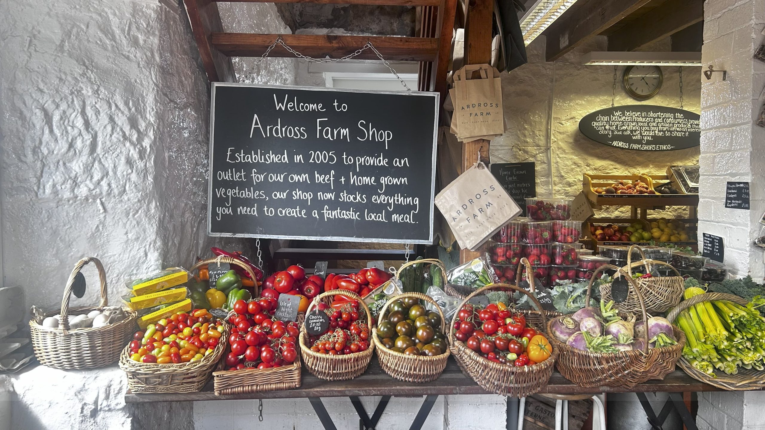 Picture of baskets of vegetables on a table at the front of the shop
