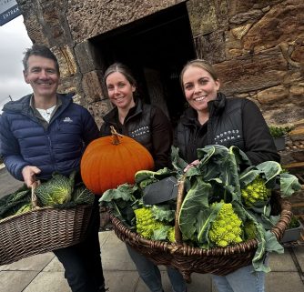 Dougie Vipond with Claire Sloan and Nikki Storrar holding baskets of vegetables