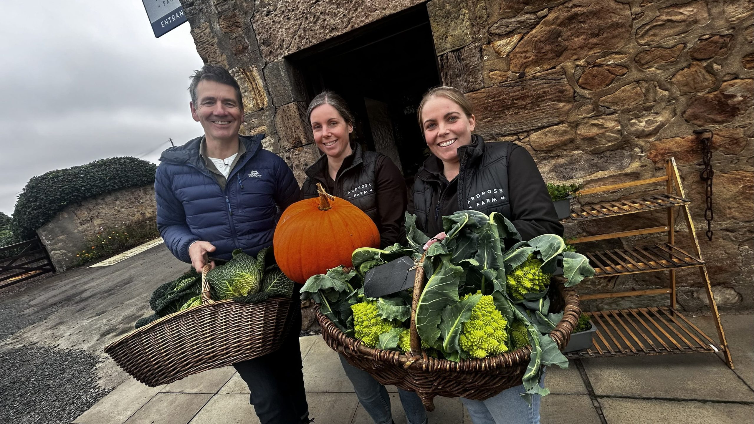 Dougie Vipond with Claire Sloan and Nikki Storrar holding baskets of vegetables