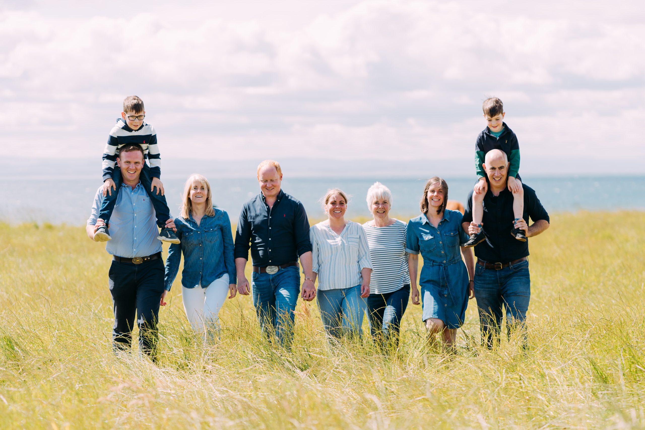 Pollock family walking in a line in a grass field.