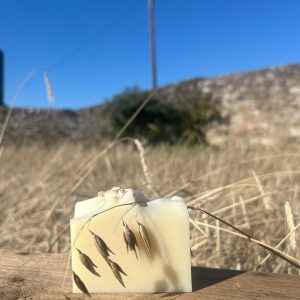 oat soap bar sitting on a wooden box in an oat field.