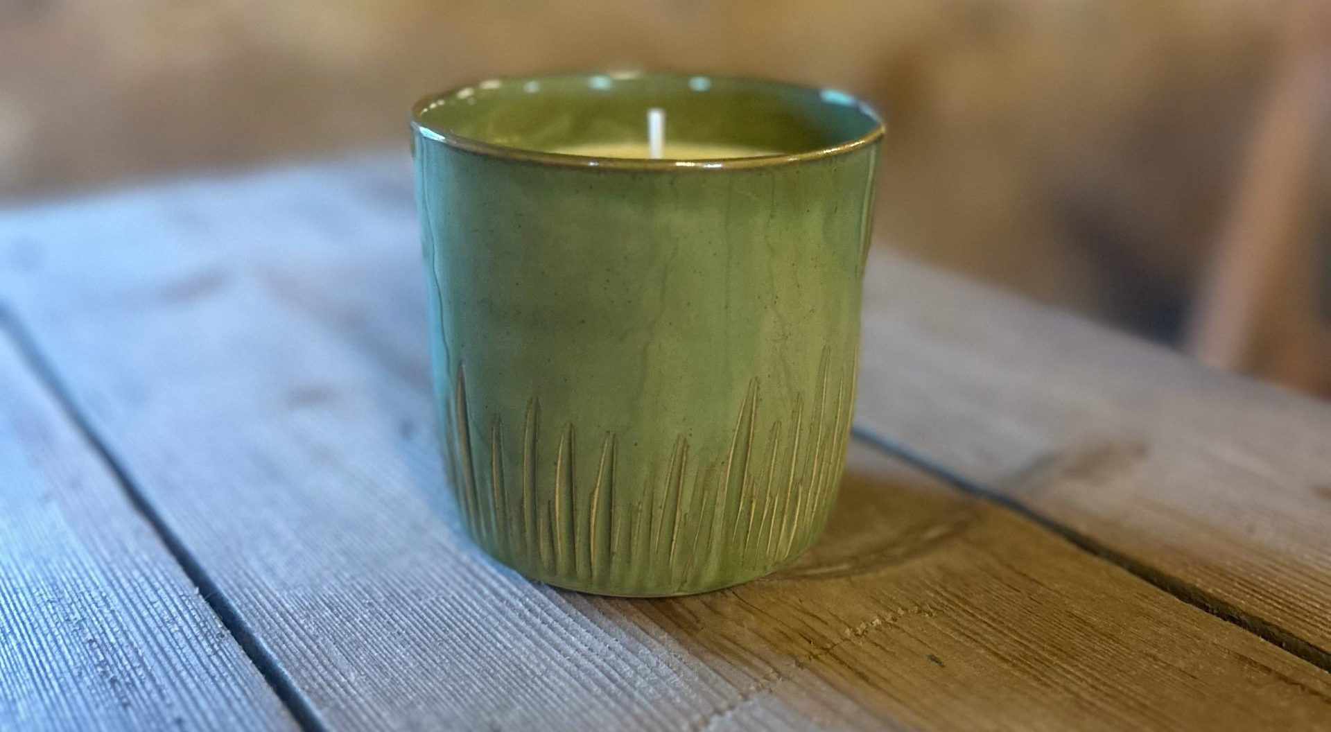 green ceramic candle with grass patterns on