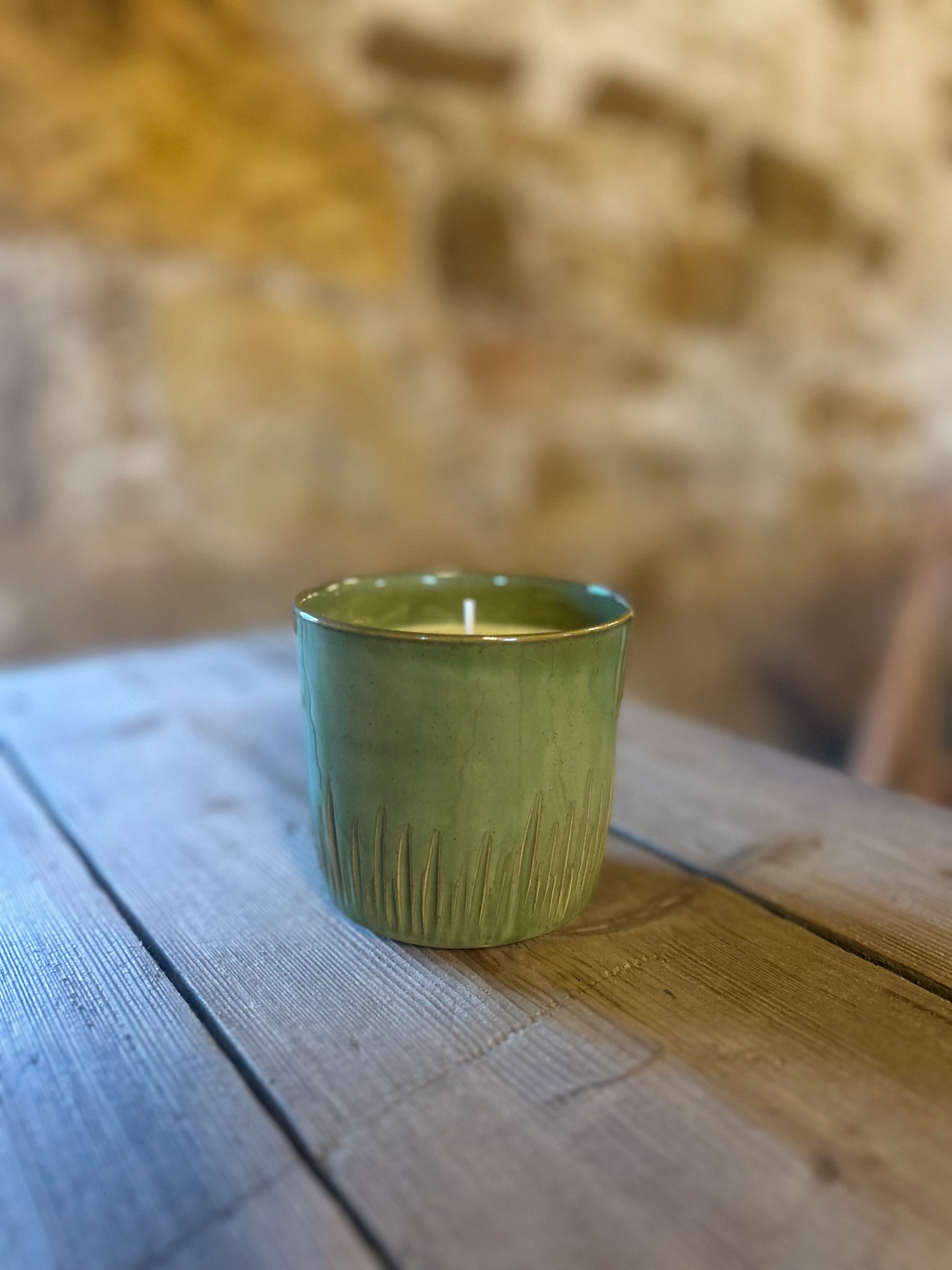 green ceramic candle with grass patterns on